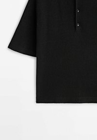 Pull en maille noir à manches courtes avec poignets et ourlet côtelés, doté d’une patte de boutonnage à trois boutons à l'avant.