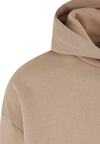 Beige Hoodie aus weichem, strukturiertem Stoff mit lockerer Passform und rundem Ausschnitt. Das Design beinhaltet ein dezentes Kapuzen-Detail.