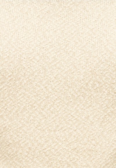 Tissu tricoté de couleur beige pâle avec un motif en chevrons texturé. Surface douce, légère et légèrement duveteuse.