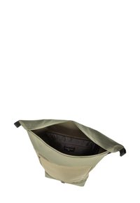 Zelena tekstilna nahrbtnik s poenostavljenim dizajnom, ki ima prostoren odprt vrh in kontrastno bež žep na sprednji strani.