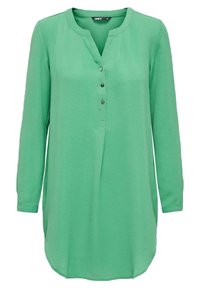 Blusa a maniche lunghe con bottoni di un vivace verde, con scollo tondo, tessuto testurizzato e spacchi laterali per facilitare i movimenti.
