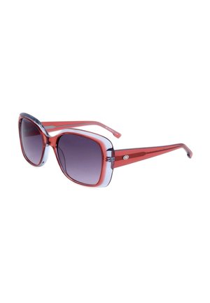 Occhiali da sole rettangolari oversize con montatura rossa traslucida e lenti scure sfumate inclinate verso destra su sfondo bianco.