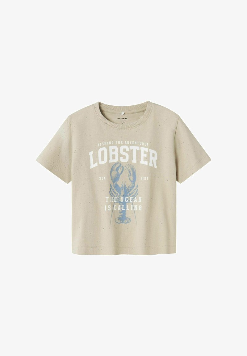 Beež lühikeste varrukatega T-särk sinise homaarigraafika ja tekstiga "Seiklusteks püüdmas" ning "Ookean kutsub." Valmistatud puuvilla segakangast.