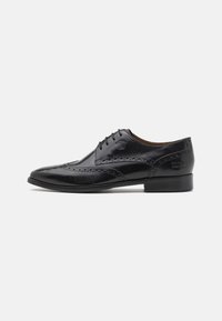 Scarpone oxford in pelle nera con dettagli brogue, design con allacciatura, punta affusolata e tacco piatto e basso. Texture liscia con logo impresso.