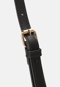 Zwarte leren band met gouden metalen gesp, voorzien van een textuur en verstelbare gaten voor lengteaanpassing.