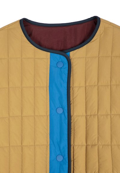 Veste matelassée beige avec boutons-pression bleus et bordure, doublure intérieure rouge foncé et encolure arrondie.