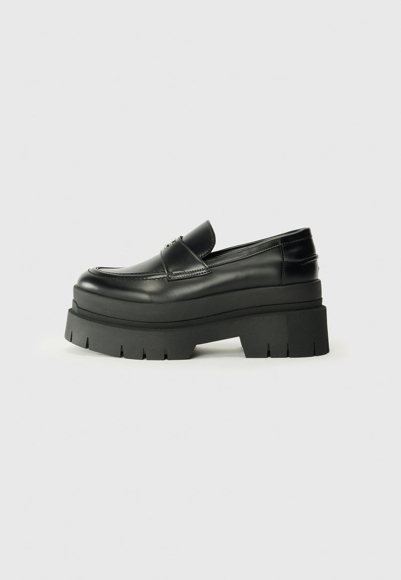 Black leather loafers with a chunky platform sole. Rounded toe, front seam detail, and subtle stitching accents. Flat, textured outsole.