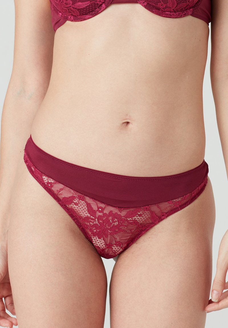 Burgunderfarbene Spitzenunterwäsche mit floralem Muster, einem glatten Bund und einem durchsichtigen Einsatz. Das Design vereint Komfort und Eleganz.