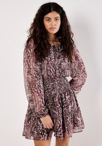 Langarmkleid mit geraffter Taille, das ein mehrfarbiges geometrisches Muster in Burgunderrot und Creme präsentiert. Weicher, fließender Stoff.