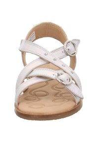 Sandalo bianco con cinturini incrociati e ritagli circolari, dotato di hardware in tono argento e una soletta liscia e testurizzata.