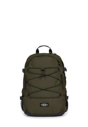 Zaino verde oliva dal design elegante, con un cordino elastico frontale, tasche laterali in rete e accenti neri. Manico rinforzato sulla parte superiore.