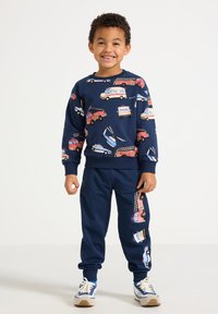 Marineblå bomulds-sweatshirt og joggingbukser med farverige køretøjsprints, der forestiller brandbiler og politibiler, med ribstrikkede manchetter og linning.