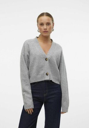 Cardigan gris court en tissu tricoté doux, avec un col en V et deux boutons marron sur le devant. Manches longues et larges.
