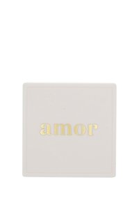 Scatola in ceramica con una superficie liscia e opaca di un rosa chiaro, con la parola "amor" impresso in lettere dorate. Forma quadrata con bordi sottili.
