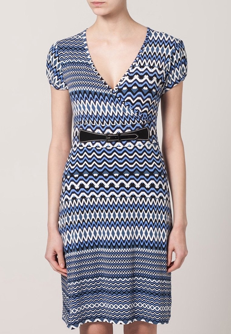 Niebieska i biała sukienka w wzór zygzakowy z dekoltem w serek, krótkimi rękawami i czarnym paskiem podkreślającym talię. Wykonana z elastycznego materiału.