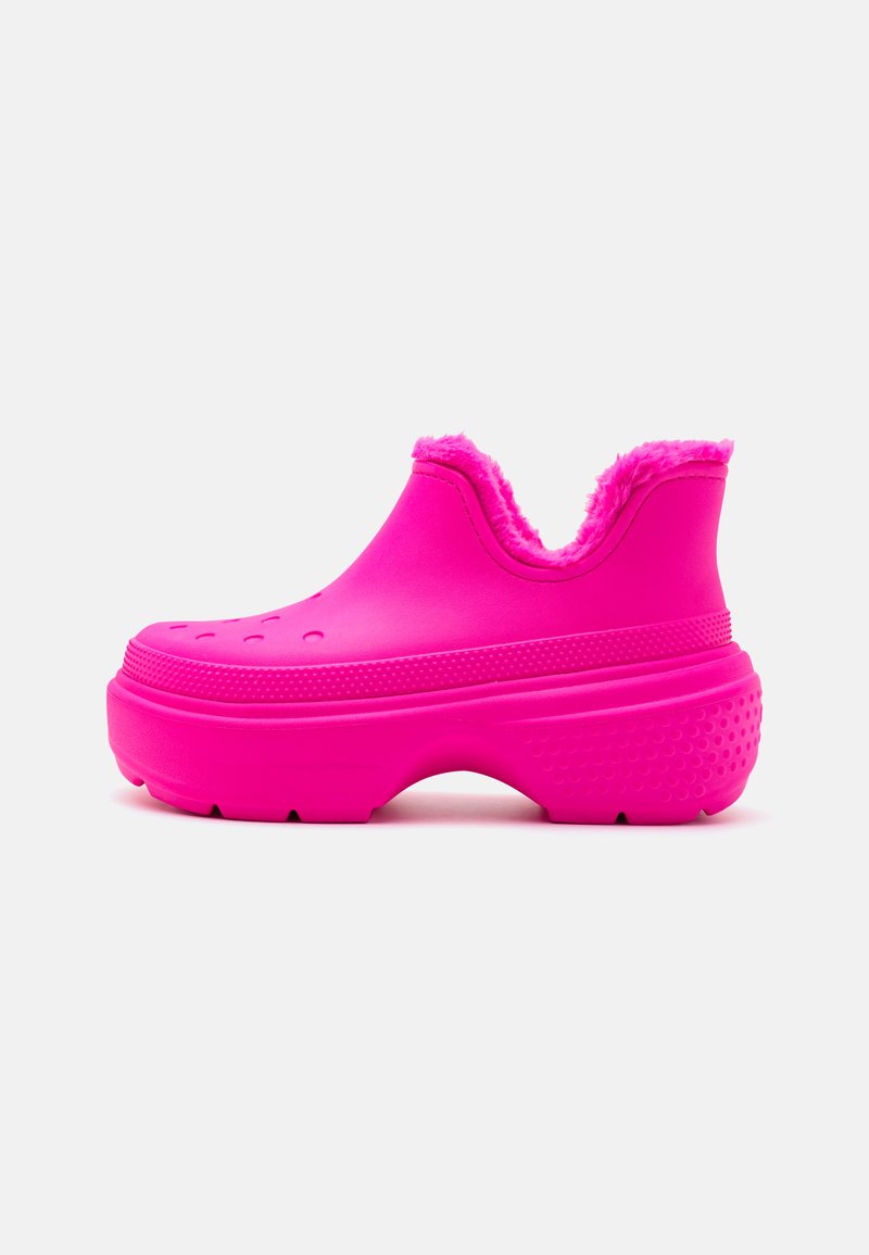 Zoccoli di gomma rosa con foderatura morbida, design perforato sulla parte anteriore e suola testurizzata per una buona presa. Tacco rialzato per maggiore comfort.
