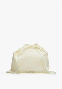 Stahovací vak z krémové tkaniny s jemnou texturou, nařaseným horním okrajem a logem potištěným ve spodní části. Dva odpovídající stahovací šňůrky pro zavírání.
