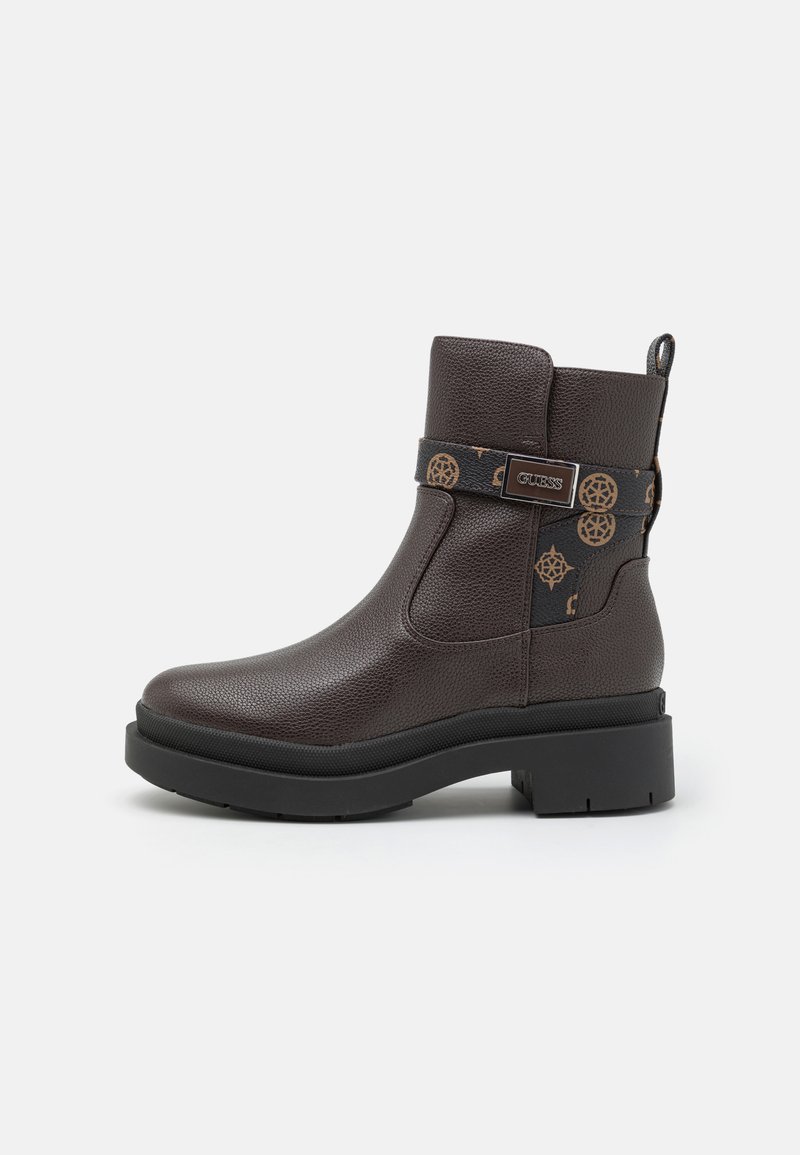 Bruine leren enkellaarzen met een gestructureerde afwerking, voorzien van een zwart patroonriem en zilverkleurige hardware aan de zijkant. Stoere zoolontwerp.