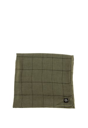 Servilleta de tela verde oliva con un sutil patrón de rejilla negro, doblada cuidadosamente, y una pequeña etiqueta negra con logo blanco en la esquina.