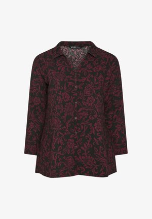 Camisa negra con patrón floral rojo, cierre de botones en el frente, cuello tipo polo y mangas largas, que muestra un tejido texturizado y un ajuste relajado.