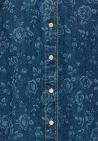 Jeans srajca z matjo temno modro cvetlično obleko, srebrnimi pritisnimi gumbi in vidnim šivanjem vzdolž središča ter gumbne liste.