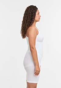 Rochie modelatoare albă, confortabilă, cu bretele ajustabile, textură netedă, lungime până la genunchi, design ajustat și construcție fără cusături.