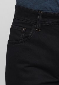 Zwarte denim jeans met een slim fit, voorzien van een vijfzakkenontwerp, contrasterende stiksels en een stevige tailleband. Soepele textuur.