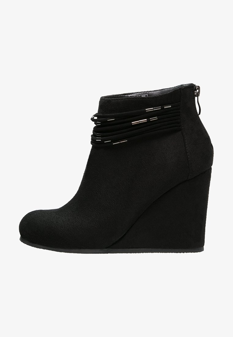 Bottines à talon compensé noires en velours doux avec un bout rond. Présente des courroies superposées avec des accents métalliques et une fermeture à glissière sur le côté.