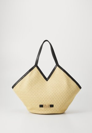 Keltainen kudottu olkakassi, jossa on V-muotoinen yläosa, musta keinonahkareuna, kaksinkertaiset kahvat ja kultasävyinen logoyksityiskohta edessä.