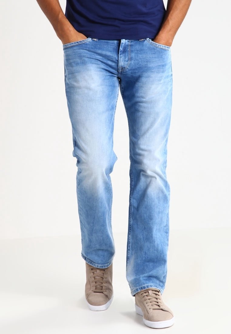 Ljust blå denimjeans med rak skärning, urtvättad framtill, fem fickor och synlig sömnad. Matchas med bruna sneakers.