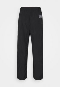 Svarta lätta byxor med elastisk midjeband, raka ben och en liten märkeslapp på baksidan till höger.