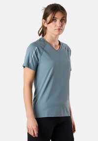 V-hals sportshirt in lichtblauw, gemaakt van ademend materiaal met een gestructureerd oppervlak. Heeft korte mouwen en reflecterende details op de schouders.