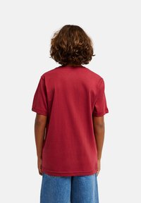 Μπορντό βαμβακερό μπλουζάκι με κοντά μανίκια, στρογγυλή λαιμόκοψη και ευθεία γραμμή. Διαθέτει απλό σχέδιο και άνετη εφαρμογή, εμφανιζόμενο από πίσω.