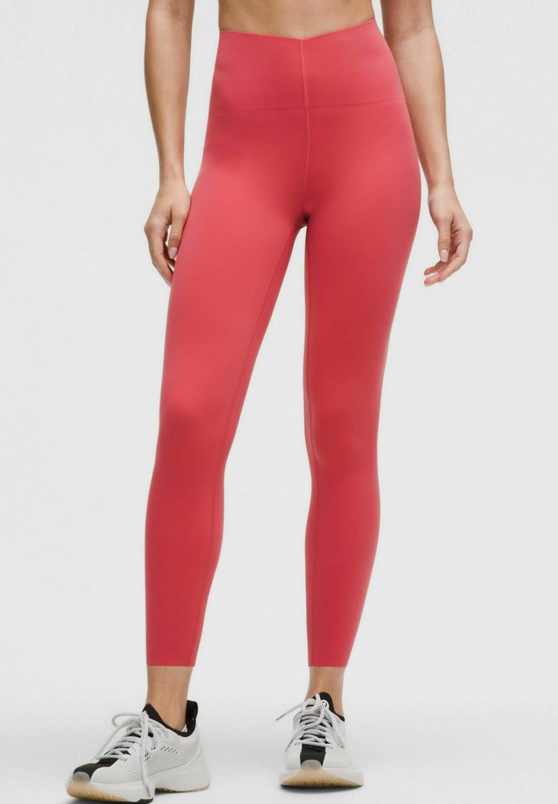 Leggings închise, cu talie înaltă și care se potrivesc pe corp, de culoare corai solidă, realizate dintr-un material elastic. Au o textură netedă, fără modele sau accesorii vizibile.