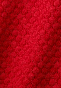 Gros plan d'un tissu rouge tricoté serré avec une texture côtelée diagonale visible.