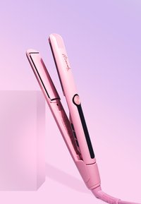 Roze haarstyler met een elegant ontwerp, gladde keramische platen, een ronde knop en bedieningsknoppen op de handgreep. Lichtgewicht met snoer.