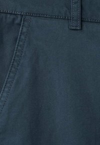 Tissu bleu marine en mélange de coton avec une texture lisse, doté d'une poche avant et d'une ceinture plate avec des détails cousus.