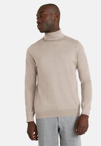 Maglione beige con collo alto, maniche lunghe e polsi a costine, realizzato in materiale morbido e leggero. Presenta una silhouette aderente.