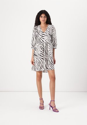 Zebra print dress in white and black, lightweight fabric, V-neckline, three-quarter sleeves, cinched waist, knee-length. Purple strappy heels.