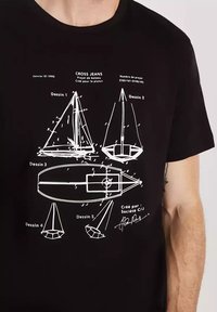 Czarny bawełniany t-shirt z białymi rysunkami technicznymi łodzi i projektów, opisanymi po francusku, w tym różne kształty i elementy.