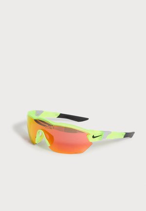 Neon sárga sport napszemüveg egyetlen narancssárga árnyalatú lencsével és fekete Nike logókkal a keret szárain.