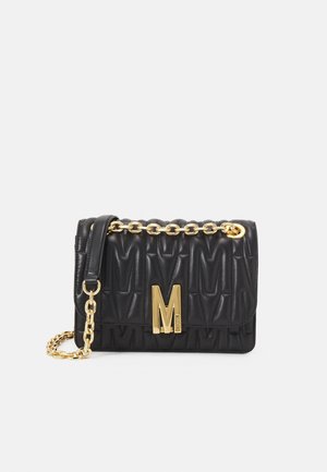 Sac à main en cuir noir matelassé avec bandoulière en chaîne dorée et grande boucle dorée en forme de M sur le rabat avant.