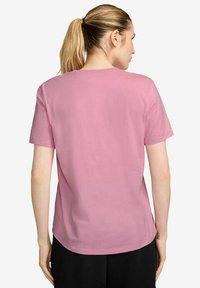 T-shirt di cotone rosa con vestibilità rilassata, maniche corte e scollatura rotonda, caratterizzata da una texture liscia e un design pulito e semplice.