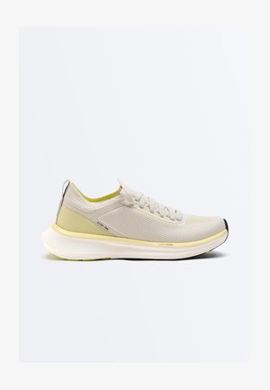 Svijetlo bež i žuta tenisica za trčanje s prozračnim gornjim dijelom od pletenine, jastučićastim potplatom, vezicama i crnim detaljima na peti i prstima.