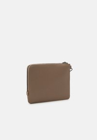 Brązowa saszetka na zamek błyskawiczny, wykonana z gładkiego materiału, w kształcie prostokąta, z eleganckim designem, widocznymi szwami oraz teksturowanym uchwytem zamka.