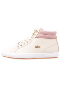Zapatilla alta de cuero crema con un collar de punto rosa, detalles en dorado y diseño de cordones; cuenta con una entresuela blanca y suela de goma color caramelo.