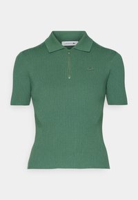Polo shirt vert à rayures avec des manches courtes, col zippé mi-long et un logo brodé subtil sur la poitrine. Fabriqué à partir d'un matériau en tricot texturé.