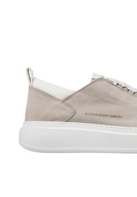 Sneaker in suede grigio chiaro con suola in gomma bianca, occhielli in argento e un discreto logo "ALEXANDER SMITH" in oro sul lato.