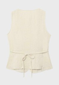 Veste sans manches crème texturée avec une ceinture nouée à l'arrière et un ourlet légèrement évasé.