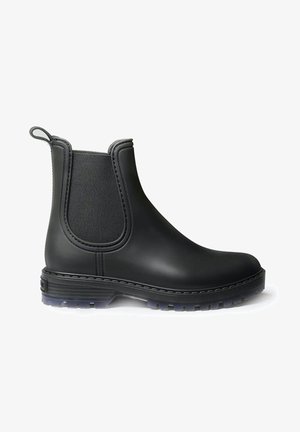 Zwarte rubberen Chelsea-boot met elastische zijkanten en een aantreklip achteraan. Kenmerkt zich door een gestructureerde zool met een doorzichtig gedeelte en gestikte naden.